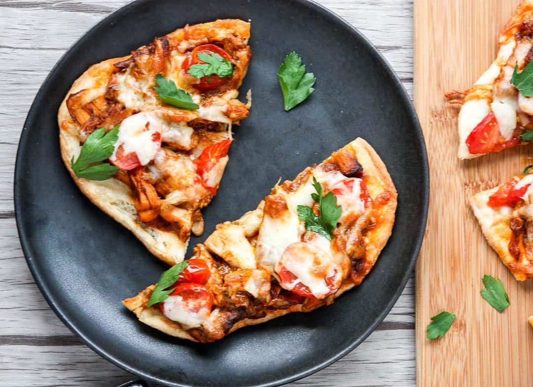 Chicken tikka masala pizza on naan bread ib a black plate