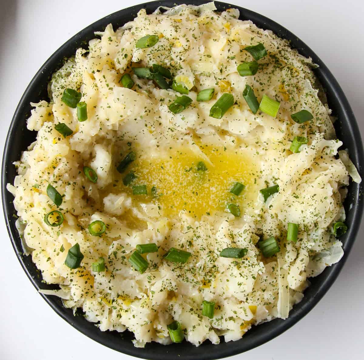 A black bowl filled with Irish mashed potatoes.